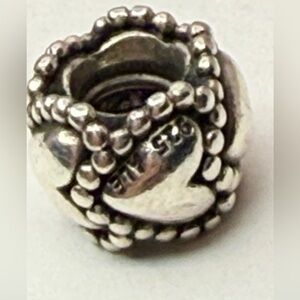 Authentic Pandora sterling silver beaded hearts band charm.